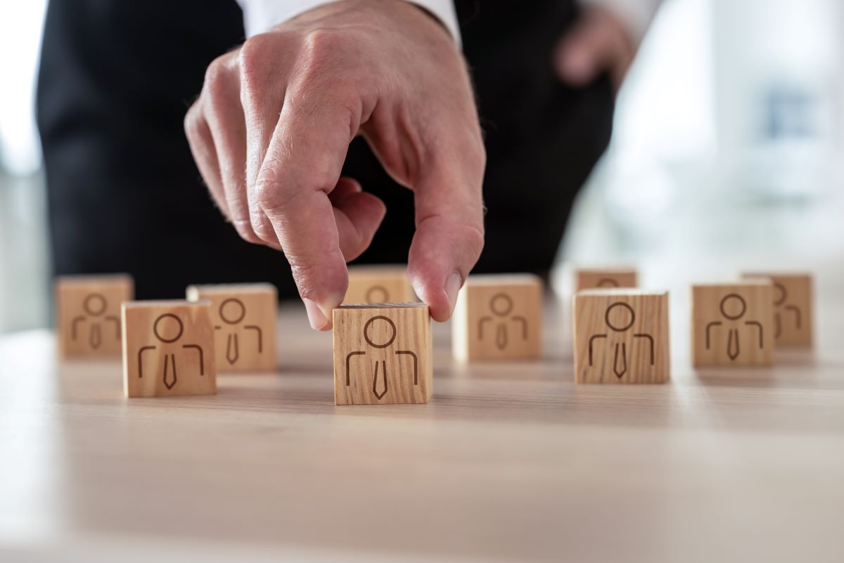 supply teacher recruitment depicted by a person picking out a figurine among other figurines