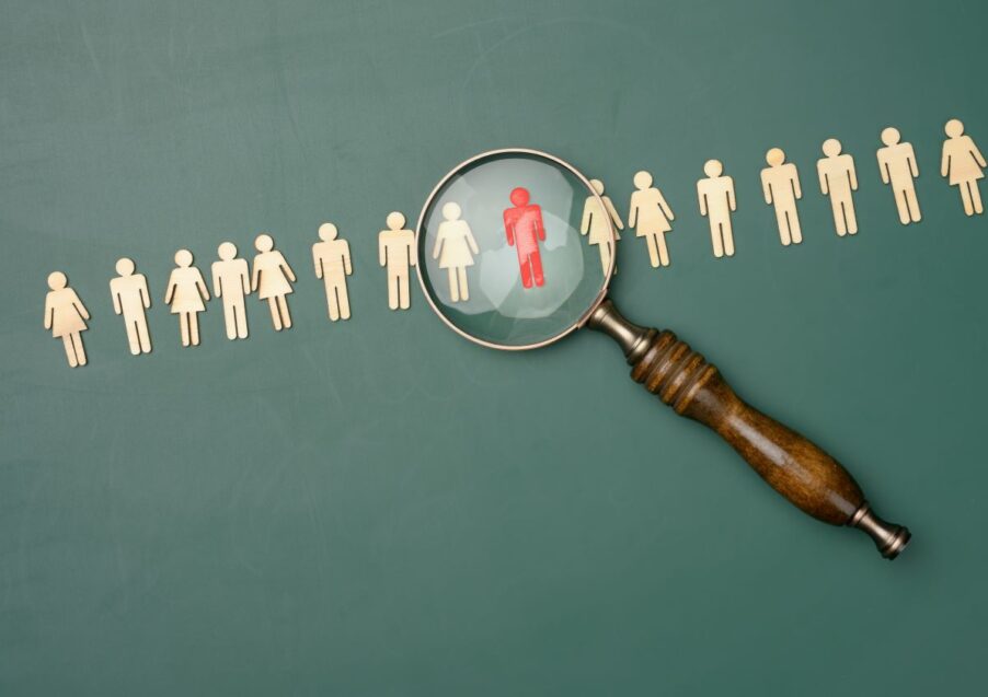 supply teacher choice depicted with a magnifying glass hovering over wooden people figurine